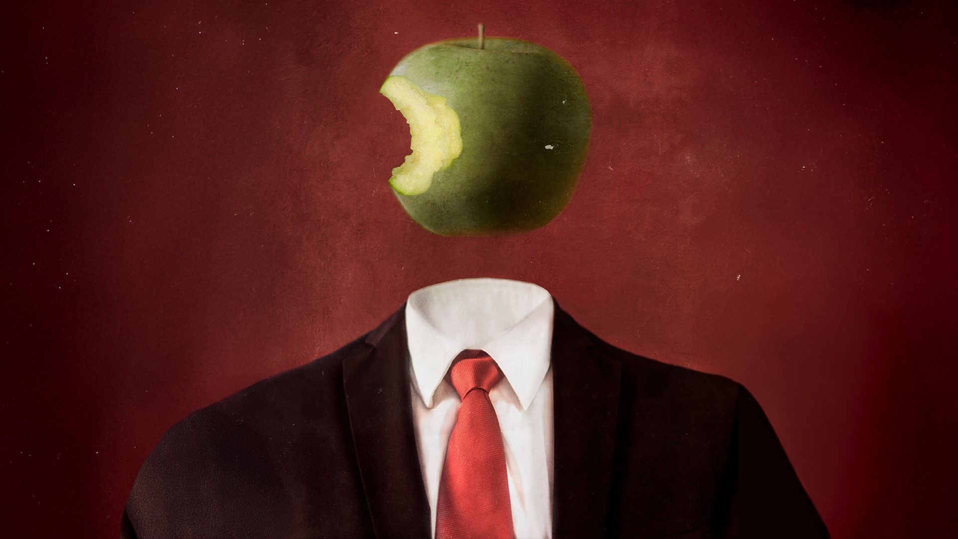Surreal illustration of a headless figure in a black suit, white shirt, and red tie, with a green apple bearing a large bite floating where the head should be, set against a dark red textured background.