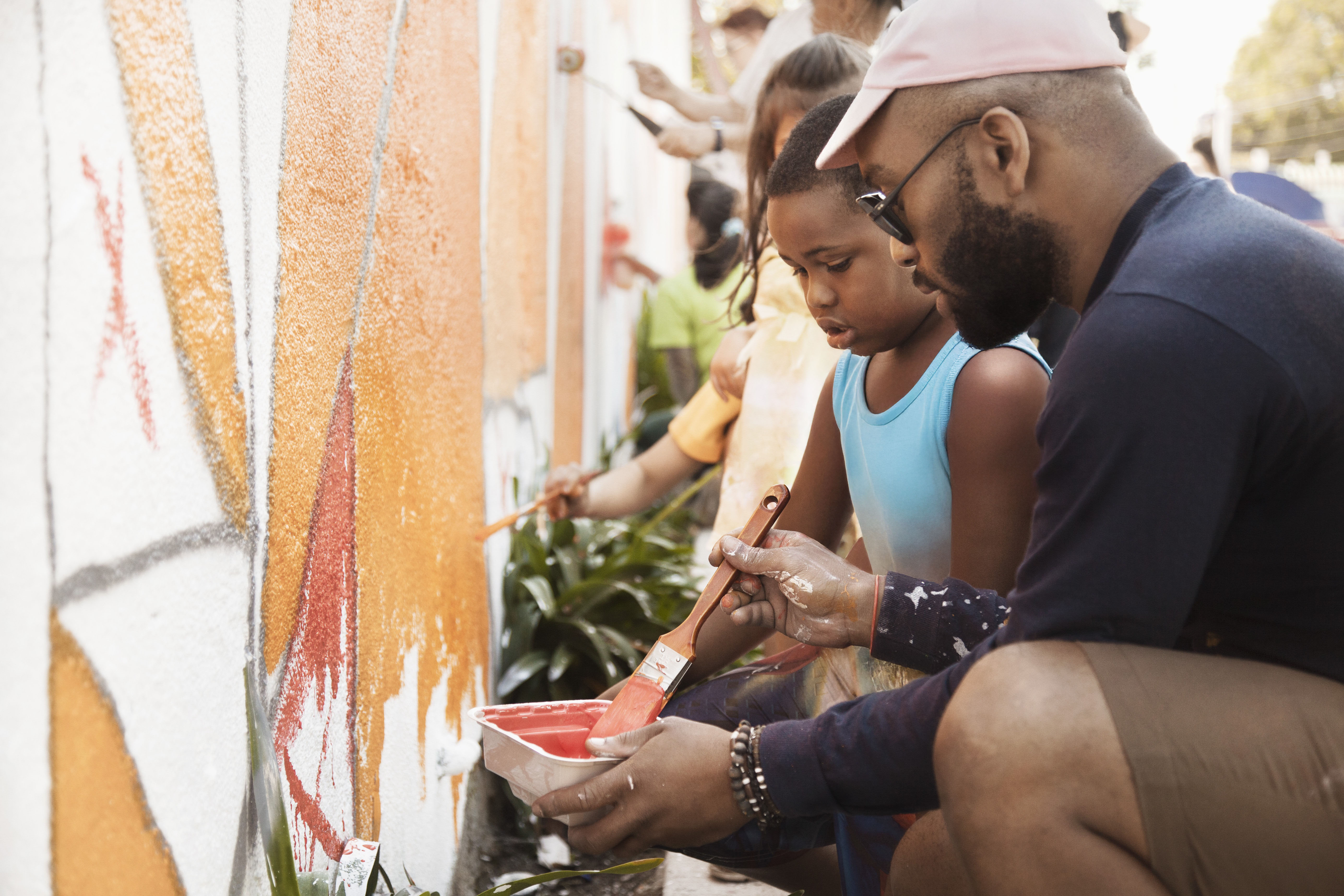 Volunteers paint a community wall with lots of colour