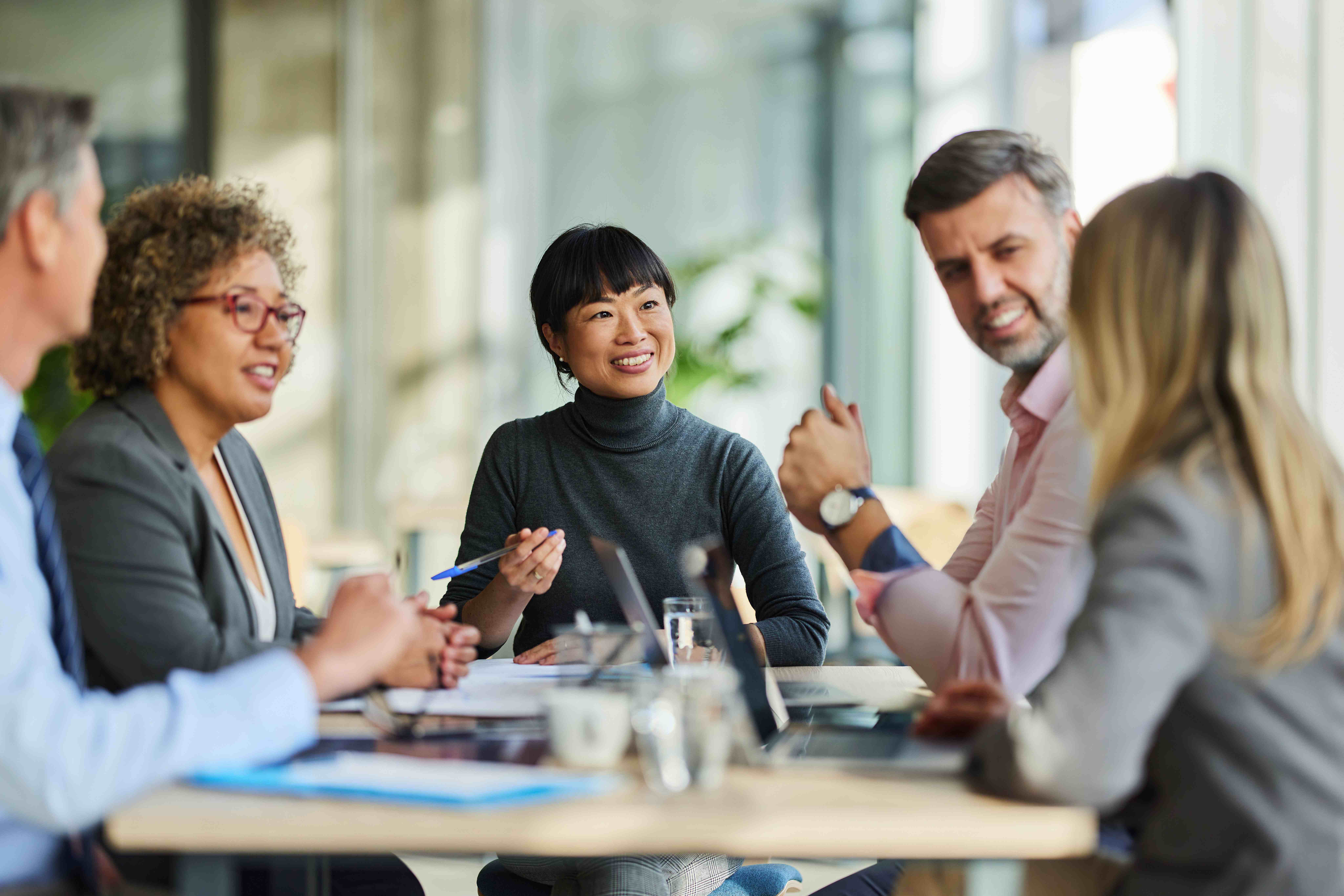 A group of colleagues discuss a topic together in the office