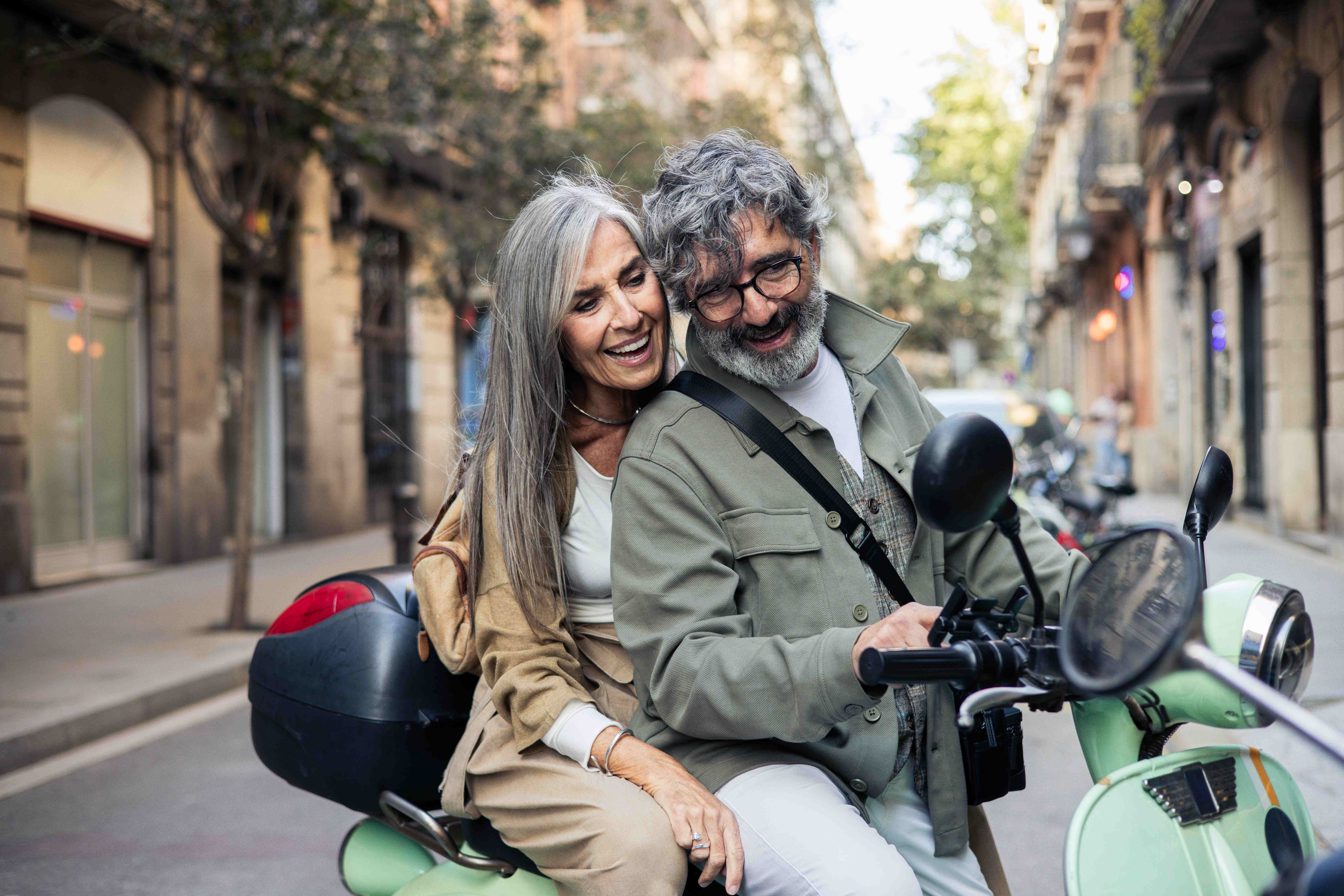 Man and women laughing on a vespa