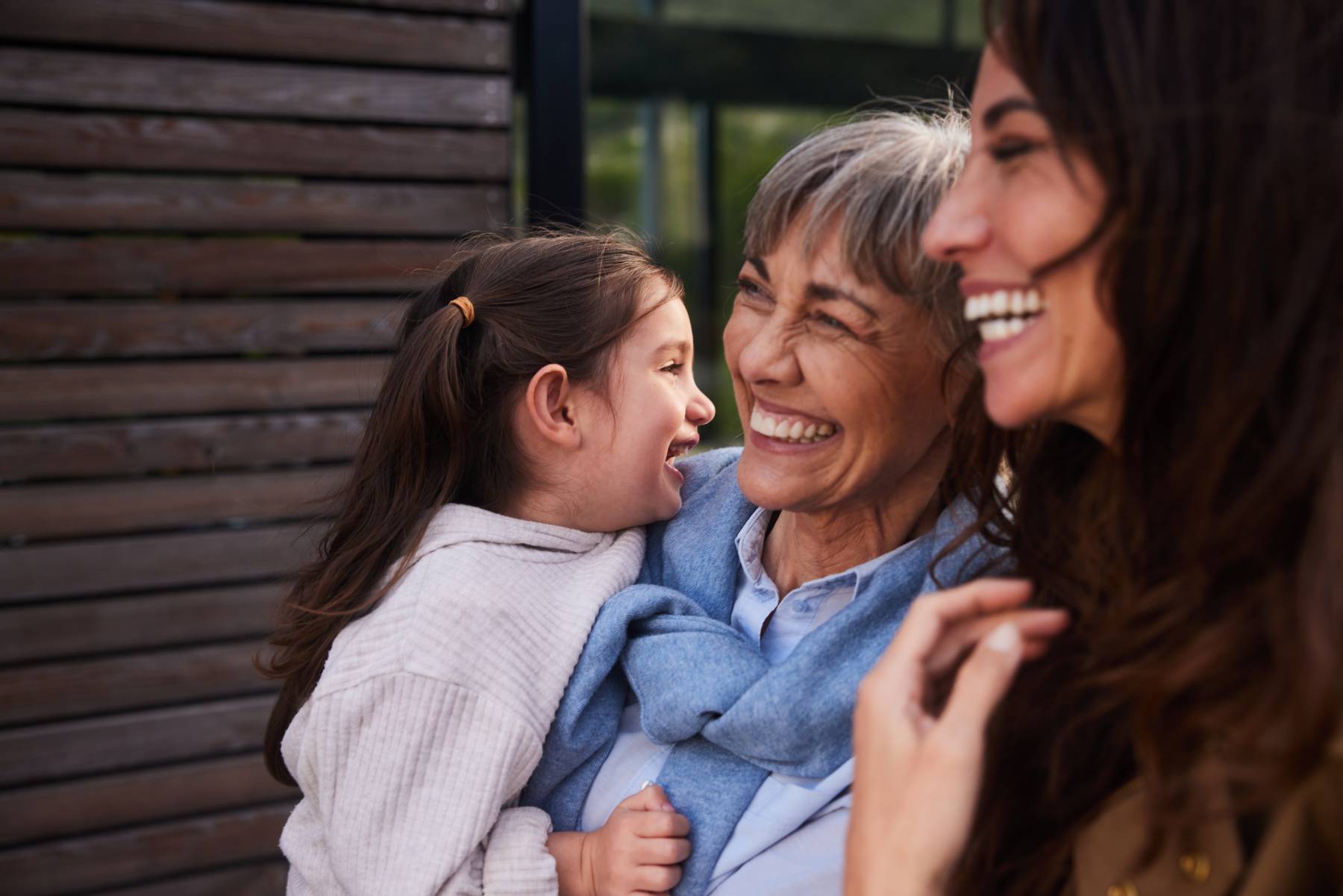 A mother, child and grandmother laugh together