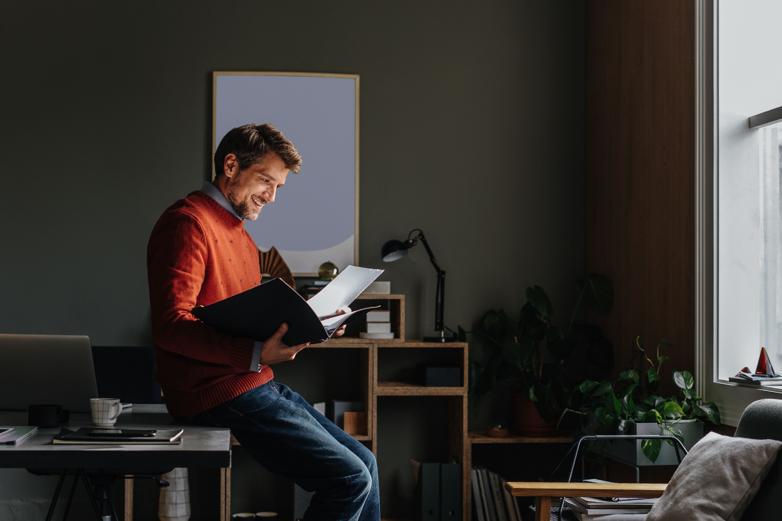 A man in his office reads a file