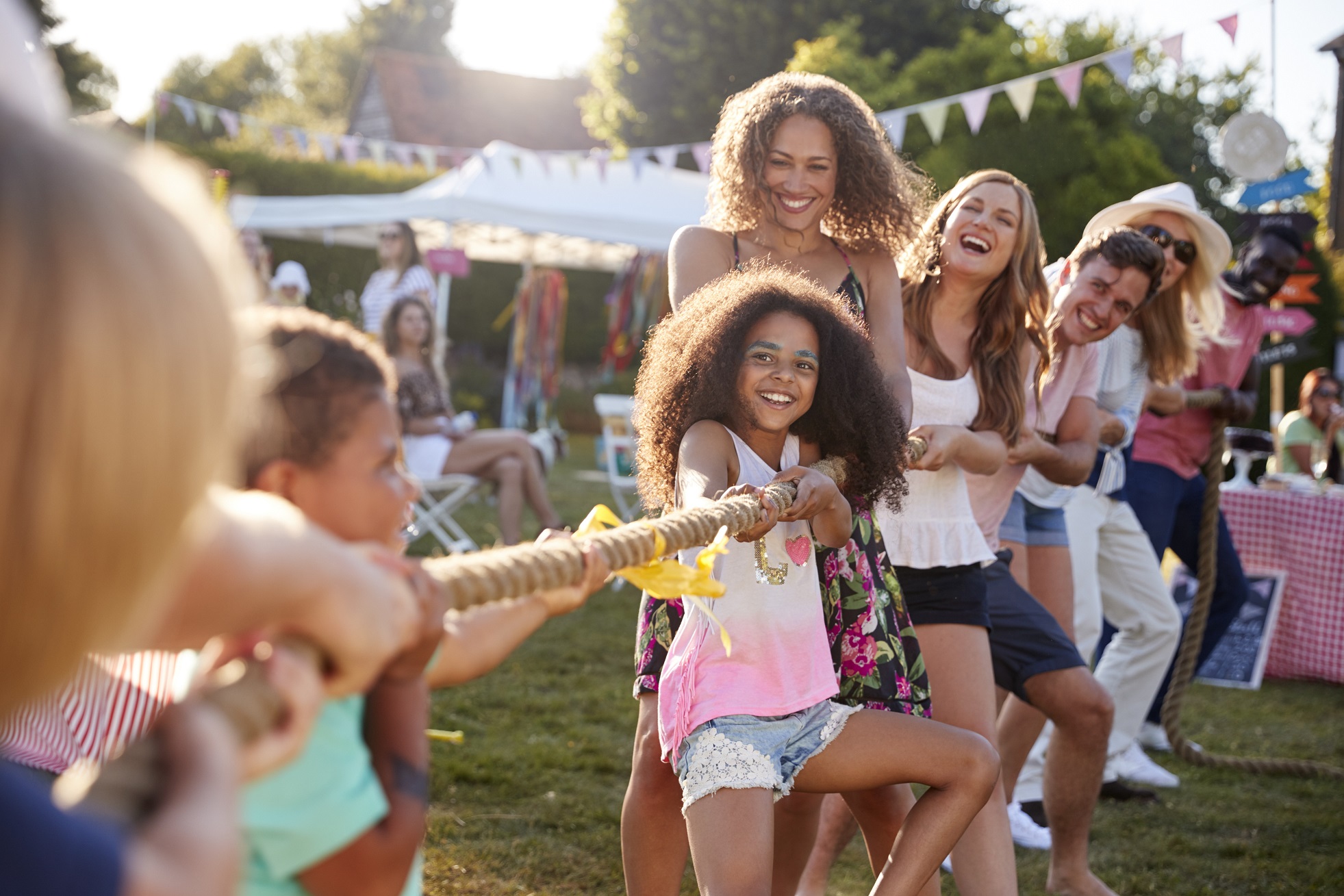 A charity trustee playing tug of war with their family at an outside event