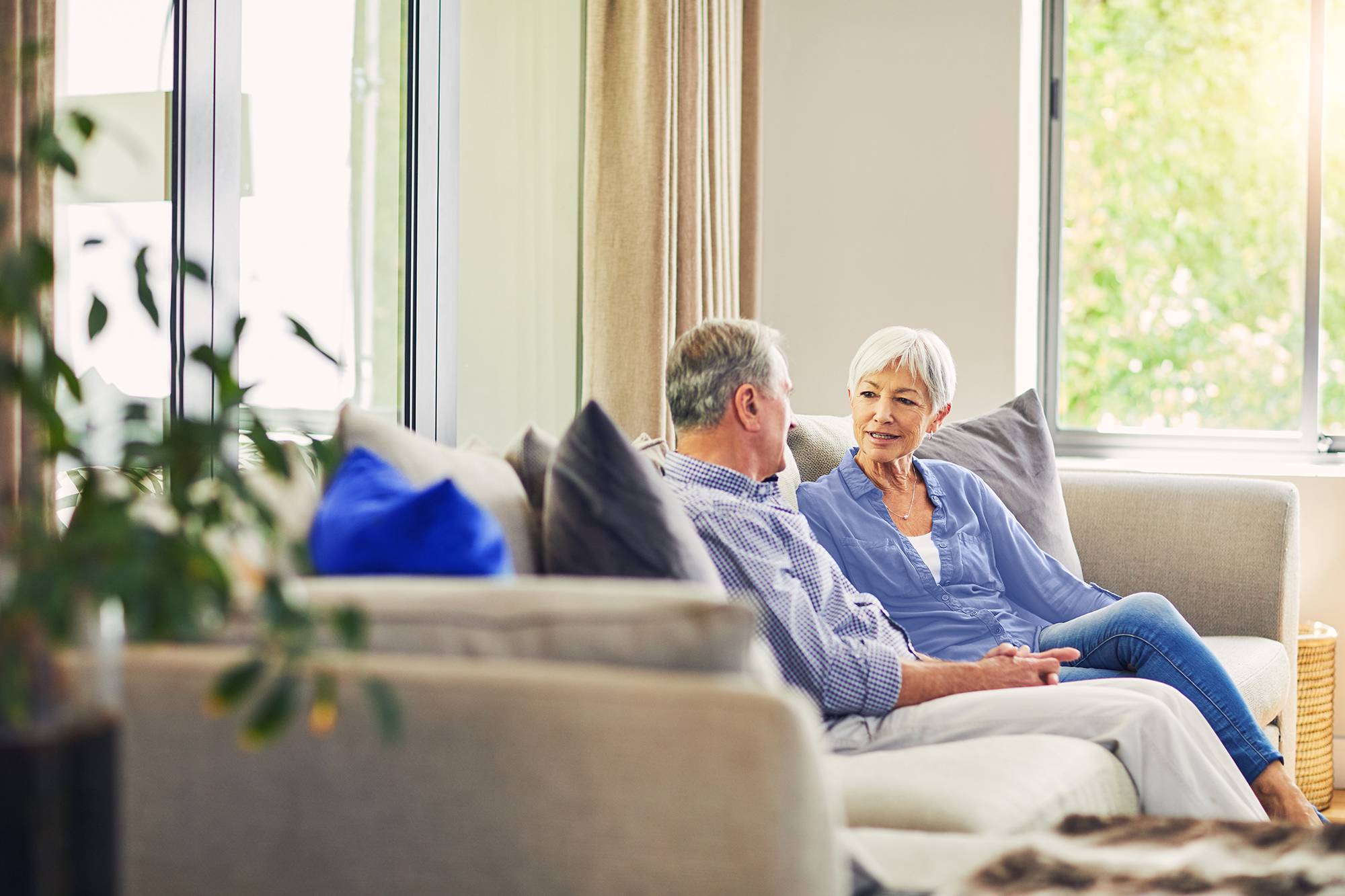 A couple having a conversation on their sofa at home