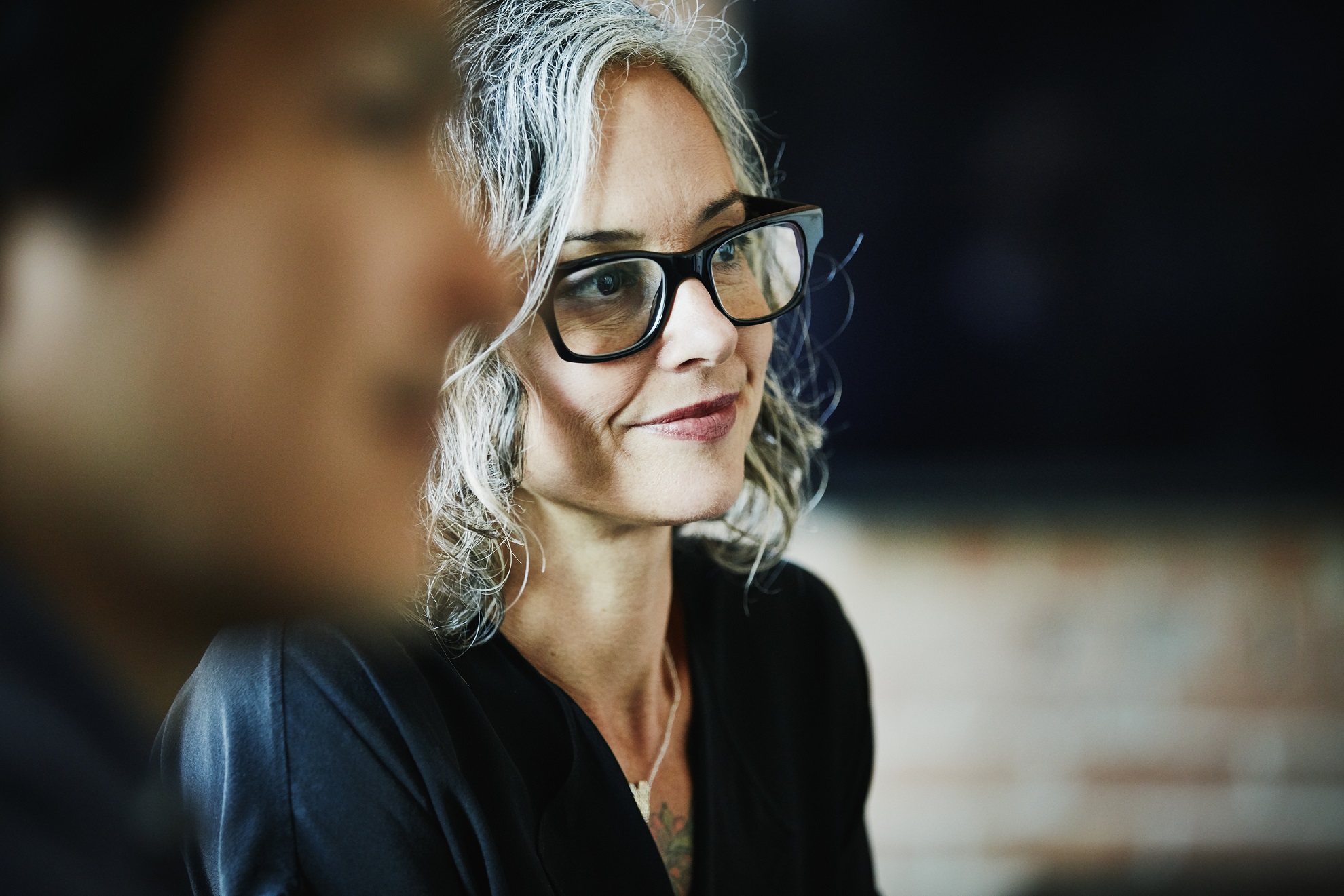 A lady wearing glasses with grey hair