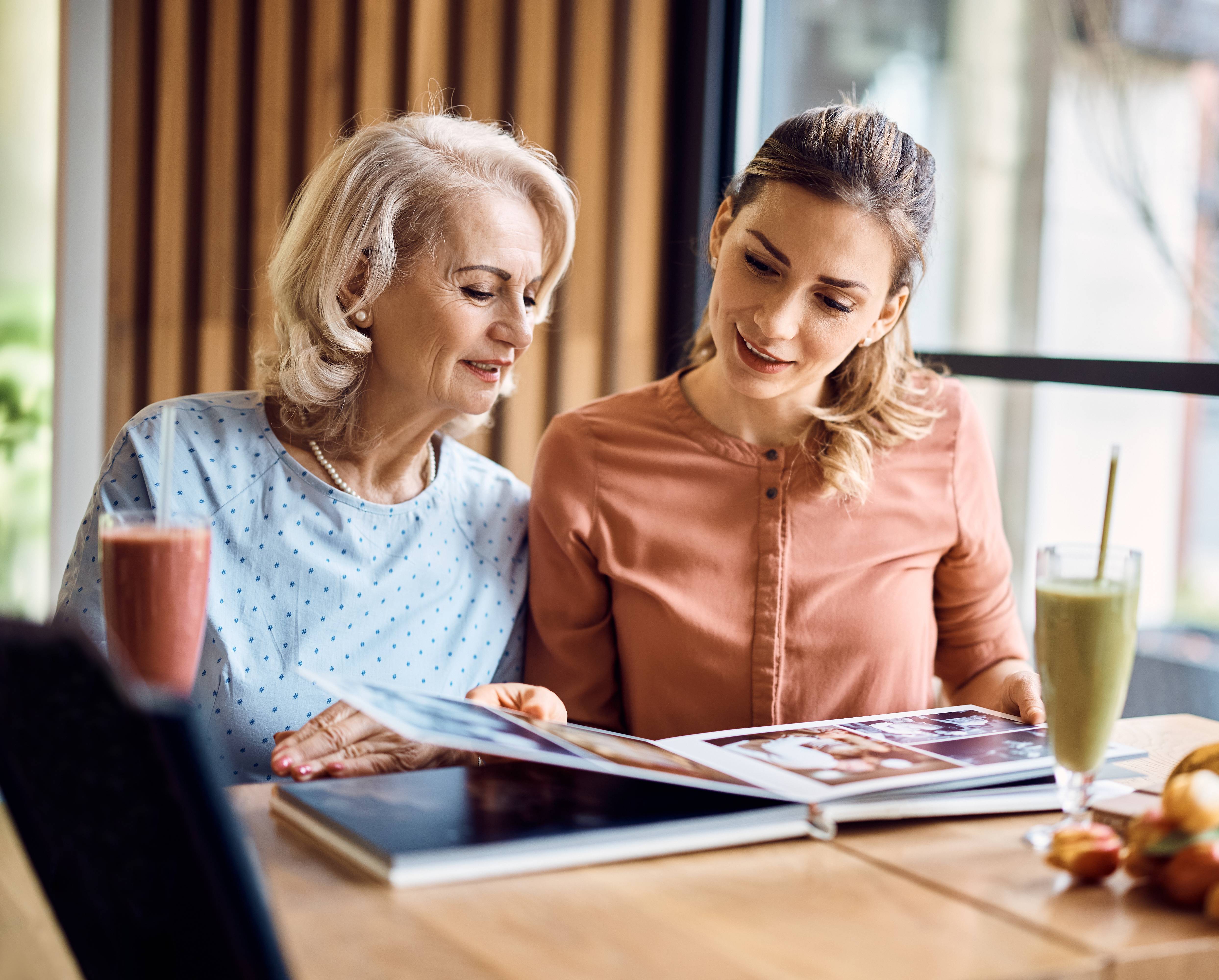 Mother and daughter looking at photo album together