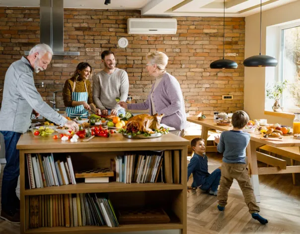 Three generations of a family in a kitchen preparing lunch
