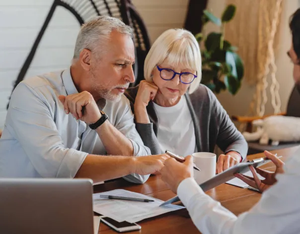 A couple look at a retirement plan with their financial planner