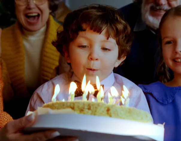 boy blowing candles