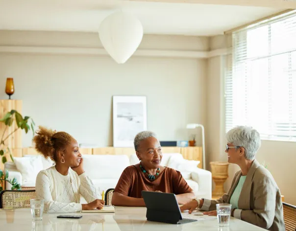 A mother and daughter meet a Rathbones financial advisor in their kitchen