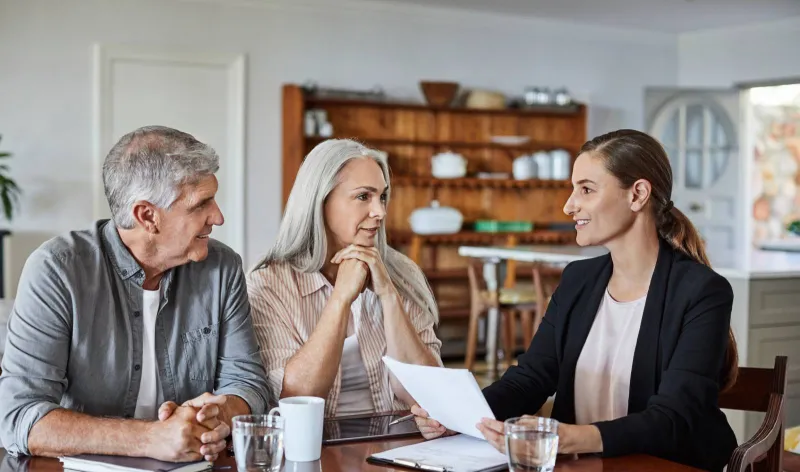 A couple meets with their financial advisers at the kitchen table