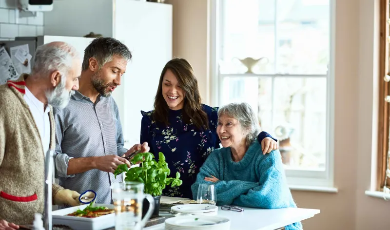 A family having a conversation while cooking dinner at home