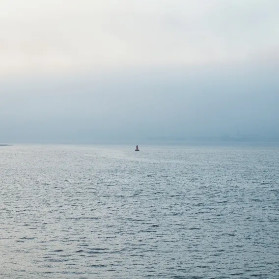 Looking across a big sea with a tiny bouy in the distance