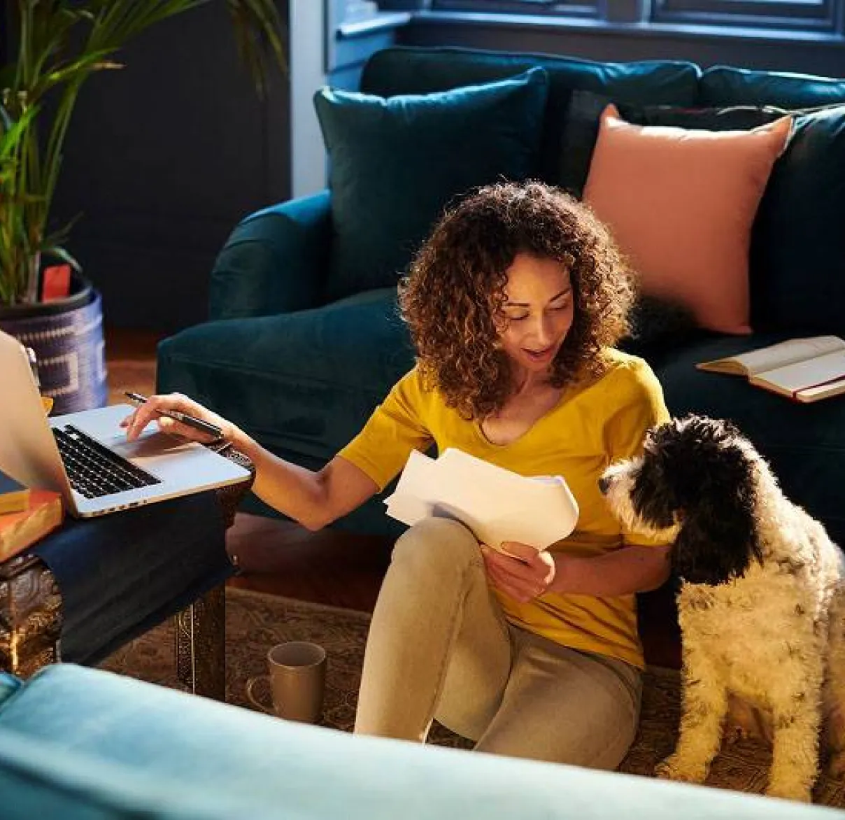 Woman looking at her finances in her living room with her dog