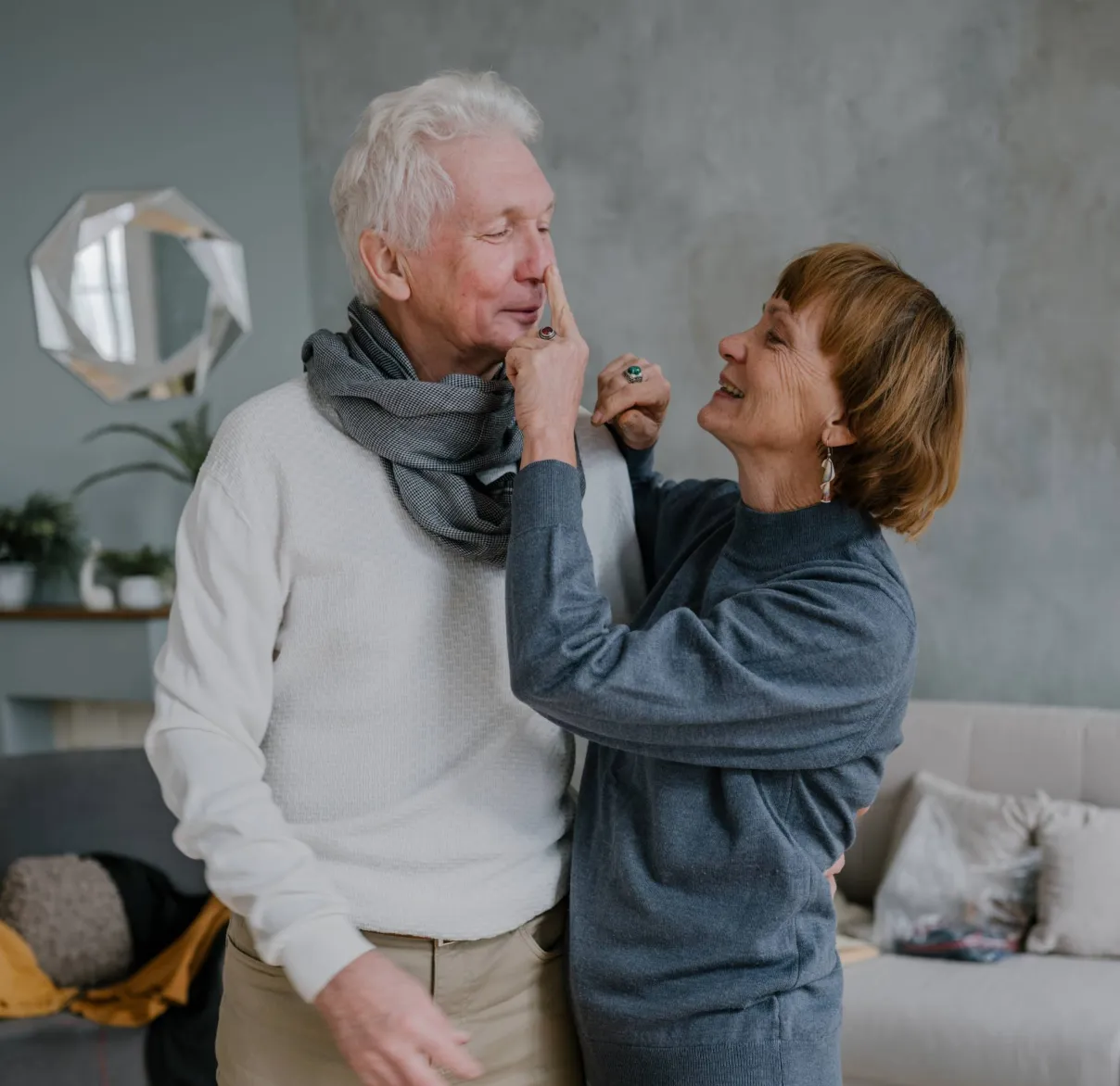 An older couple embrace in their sitting room at home