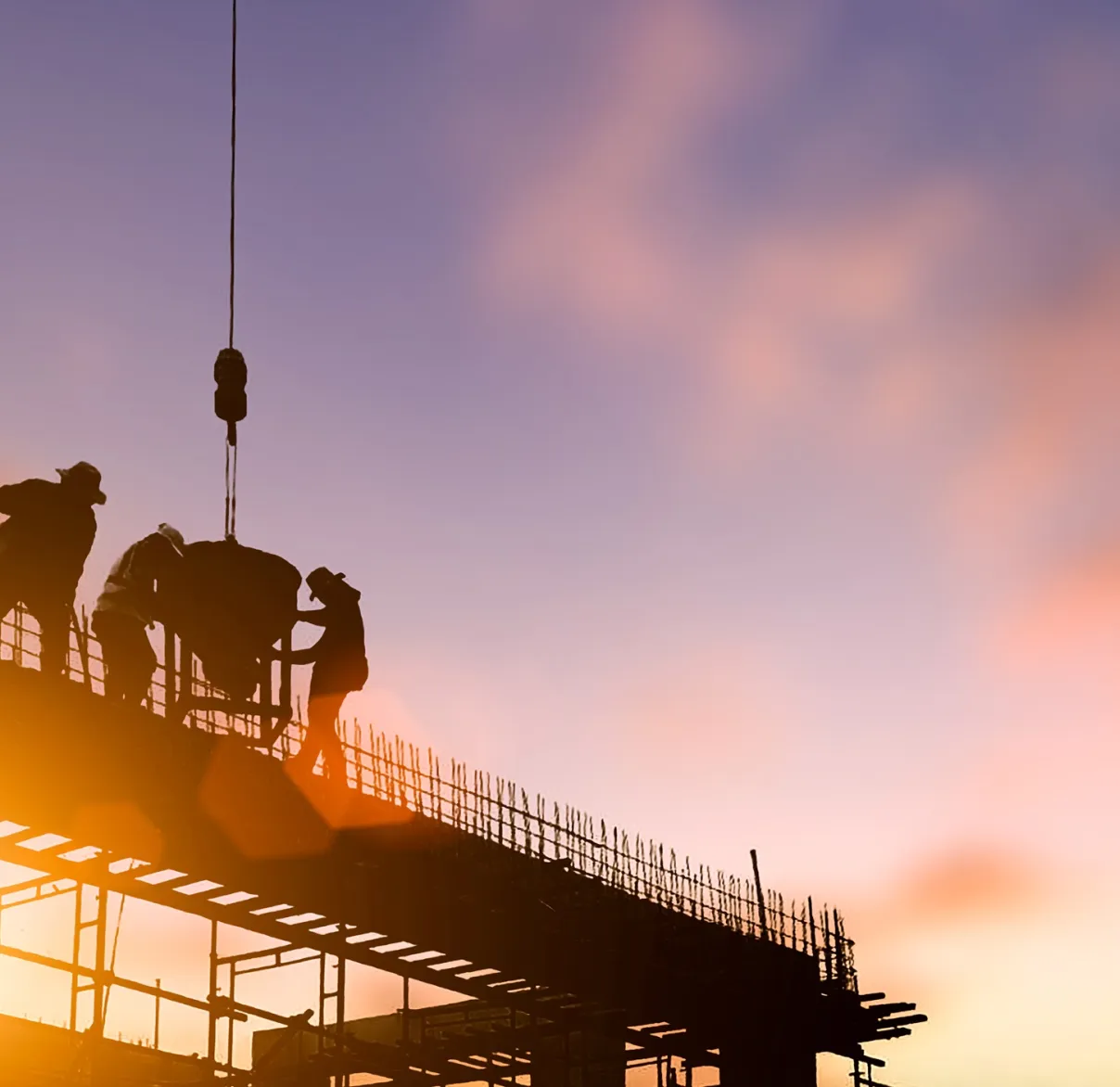 Construction workers at sunset
