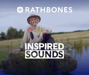 Laura Tenison MBE of Jojo Maman Bébé and Wonderful Escapes sits on a rock in the countryside, smiling at the camera