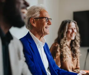 Three colleagues laugh together during a meeting