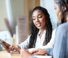 Woman looking at tablet with colleague