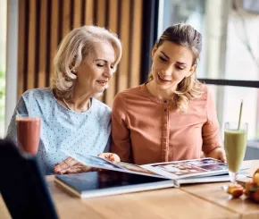 Mother and daughter looking at photo album together