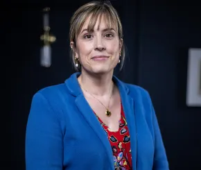 The image shows Rebecca Williams, Financial Planning Divisional Lead at Rathbones, wearing a blue blazer and red dress