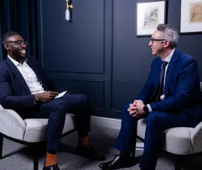 Two men sitting have a conversation