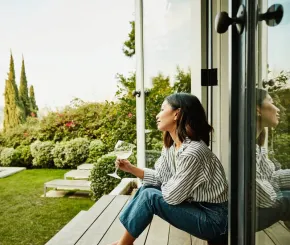 Smiling woman enjoying wine in the garden
