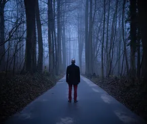 Older man walking through woods