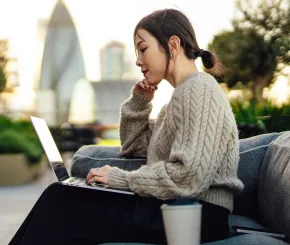 Woman working on terrace with London skyline