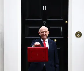Chancellor John Healey holds the Budget Box aloft in front of Number 11 Downing Street
