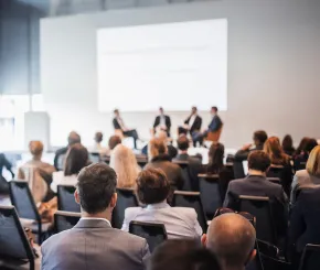 An audience listens to a panel discussion at an event