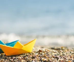 Folded paper boats on beach