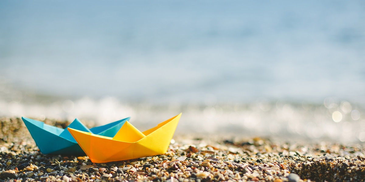 Folded paper boats on beach