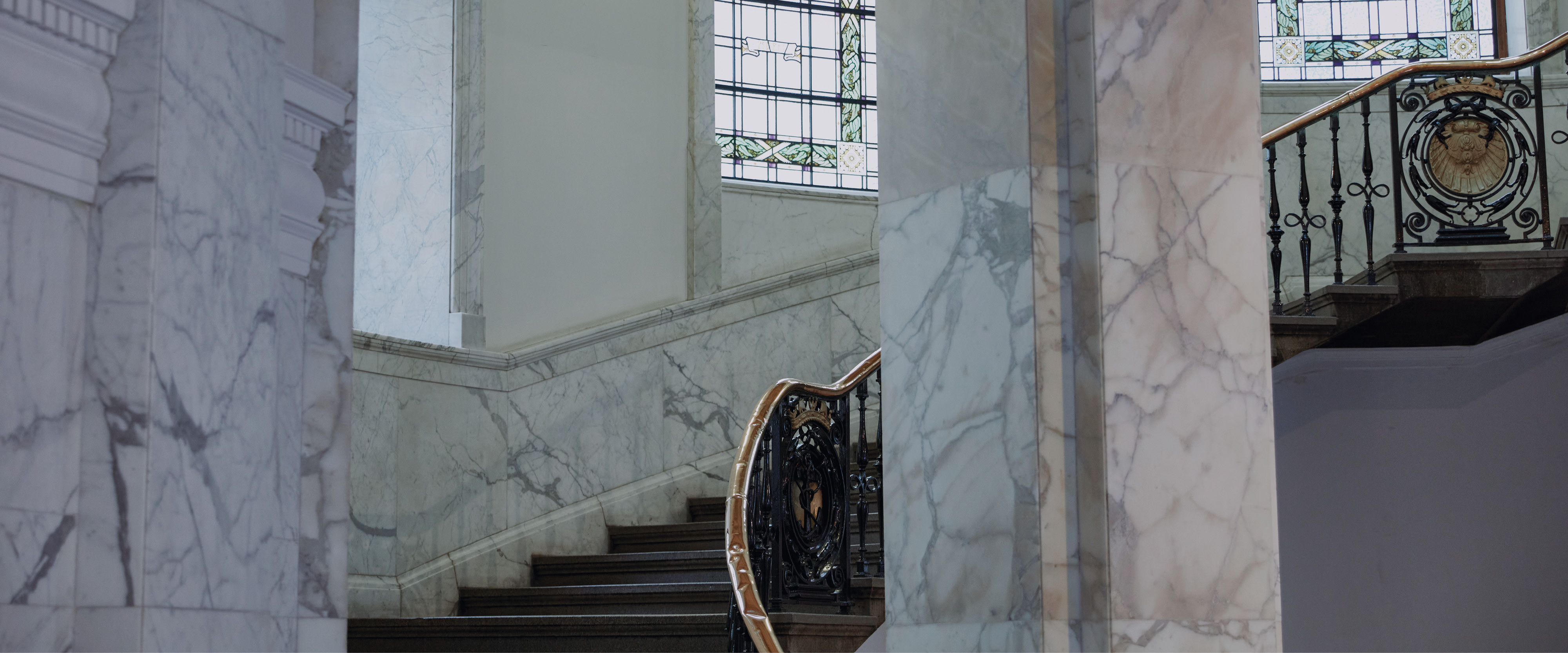 An ascending set of stairs surrounded by marble walls
