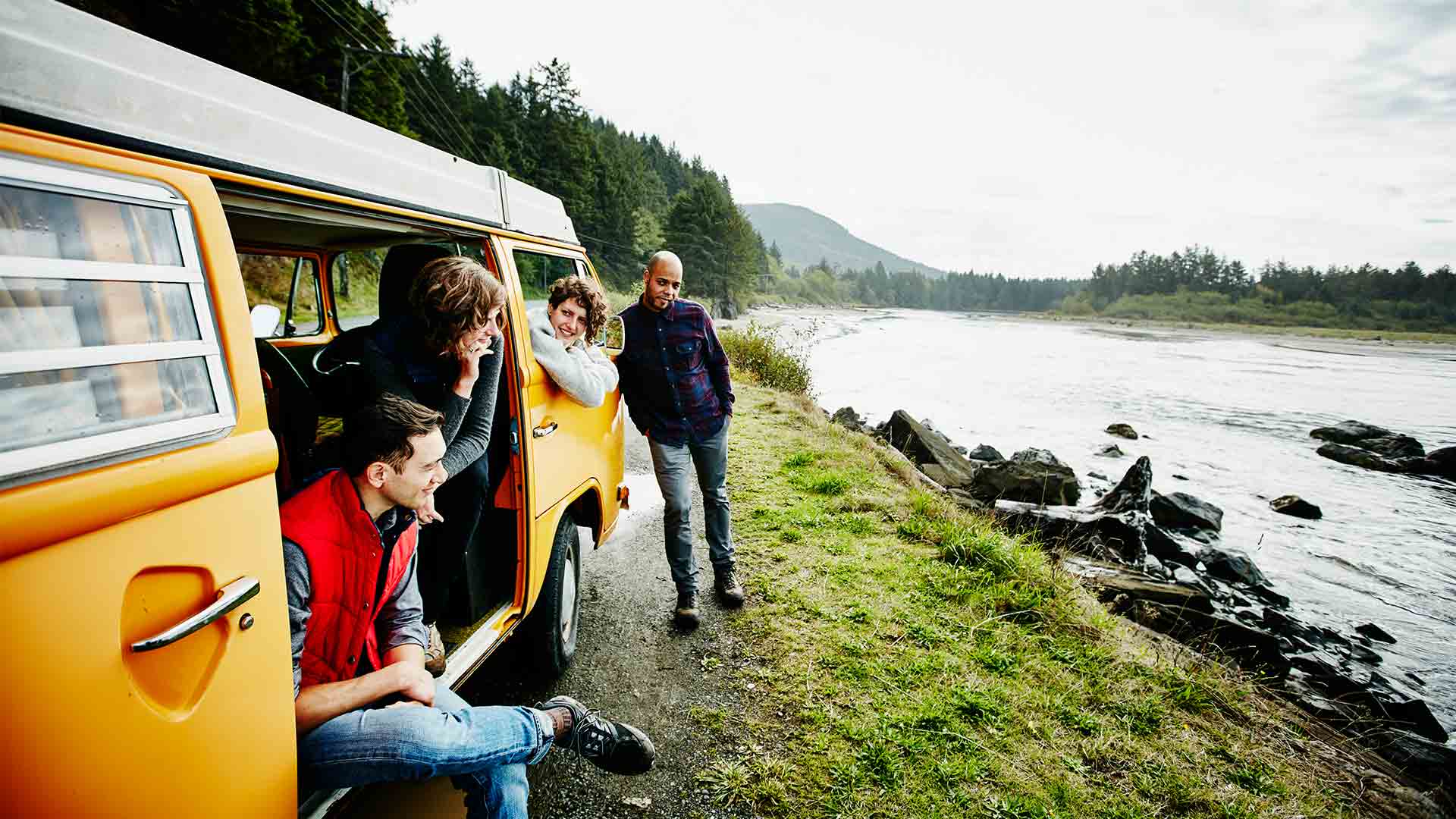 Young family with teenagers on a campervan holiday by the river