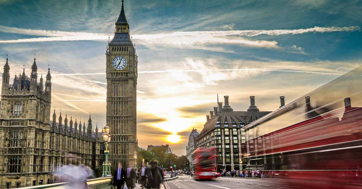 city of London facing Big Ben with an onrushing London red bus